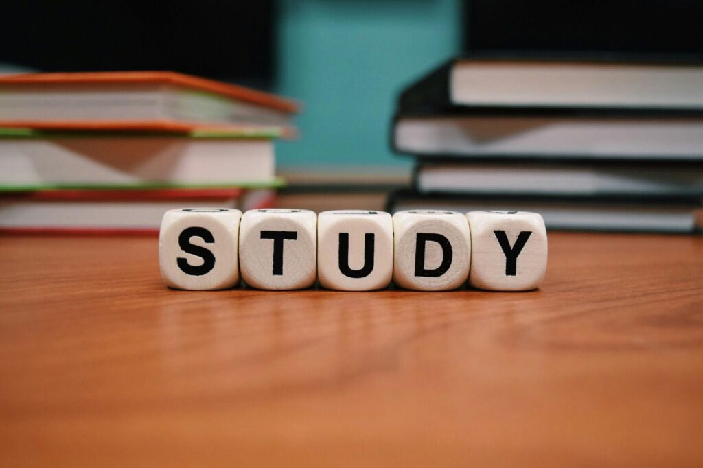 a stack of books and dice with letters on a table